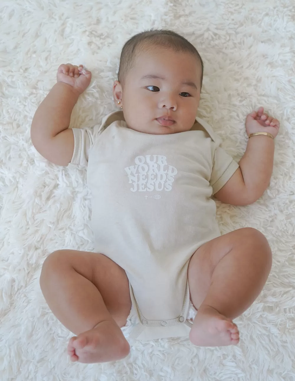 Our World Needs Jesus Beige Onesie